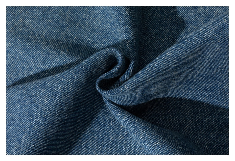 Close-up of textured blue denim fabric gathered into soft folds.