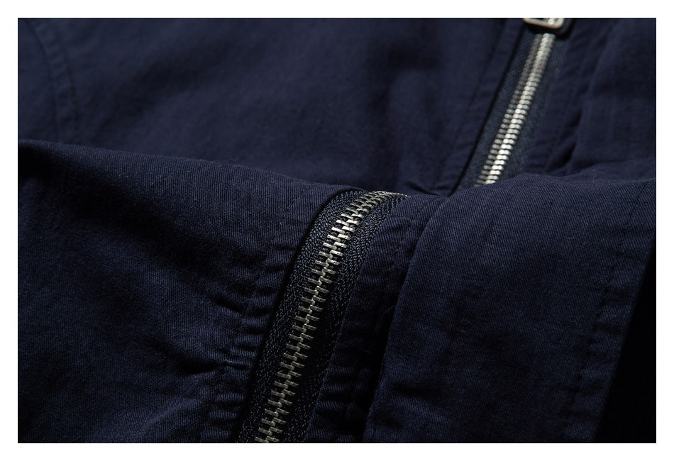 Close-up of a navy garment showing a metal zipper and stitched fabric panels.