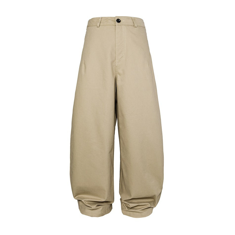 Front view of beige high-waisted trousers with a button closure, belt loops, very wide legs and gathered ankle cuffs.