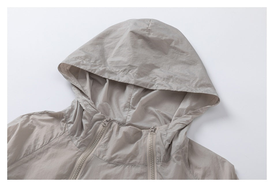 Close-up of a light taupe jacket hood and upper chest with two front zippers.