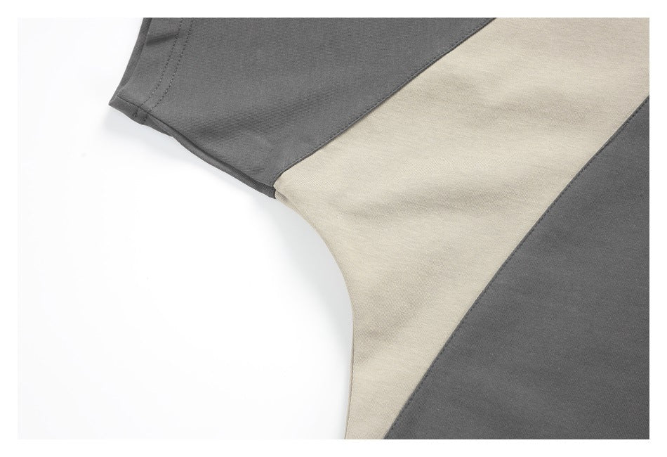 Close-up of a short sleeve and beige underarm colorblock panel on a charcoal gray top.