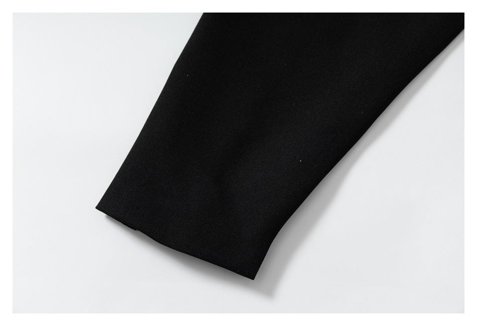 Close-up of a straight edge on black garment fabric against a white background.