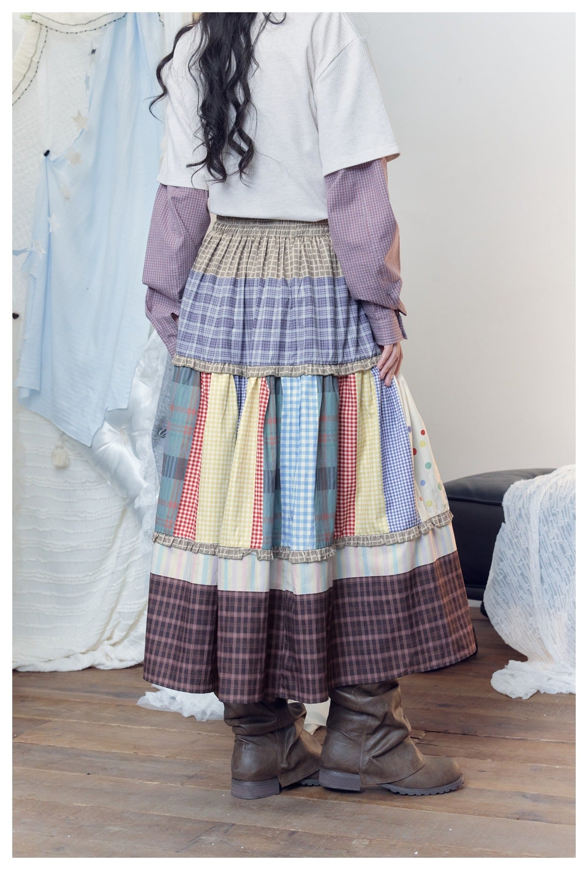 Rear view of a model wearing a long tiered skirt combining colorful checks, plaid, dots and pastel stripes.