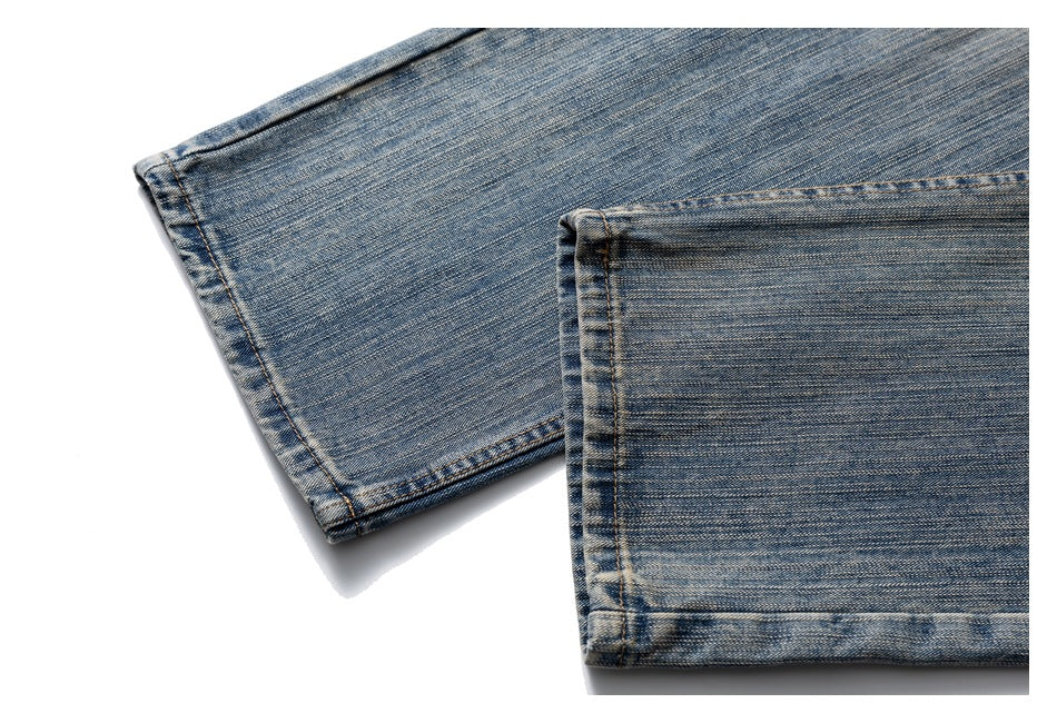 Close-up of two faded blue jean hems with visible stitching and worn wash.