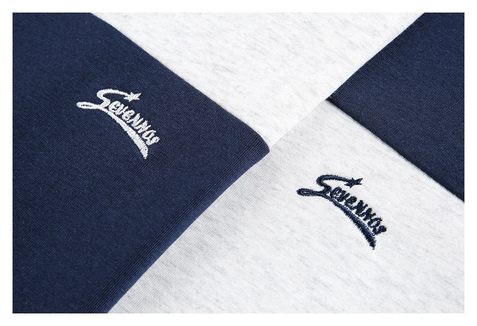 Close-up of white and navy color-block fabric with matching embroidered script logos.