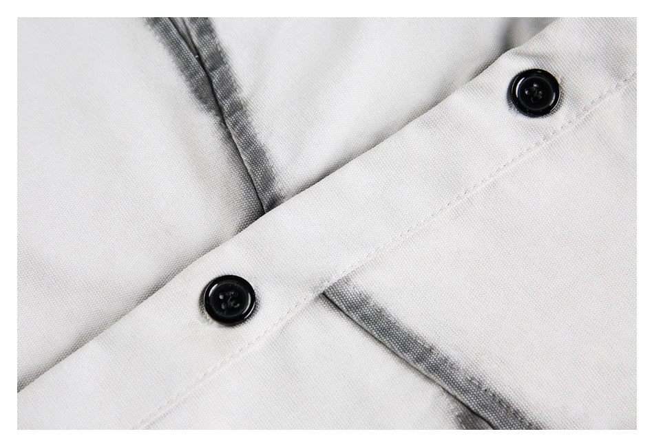 Close-up of two black buttons and dark contrast stitching on a light-colored shirt.