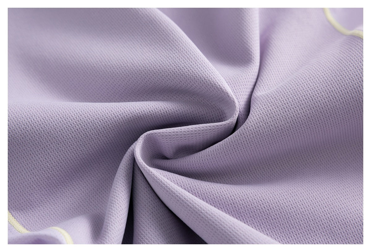 Close-up showing the textured perforated surface of lavender fabric with a small pale yellow trim edge.