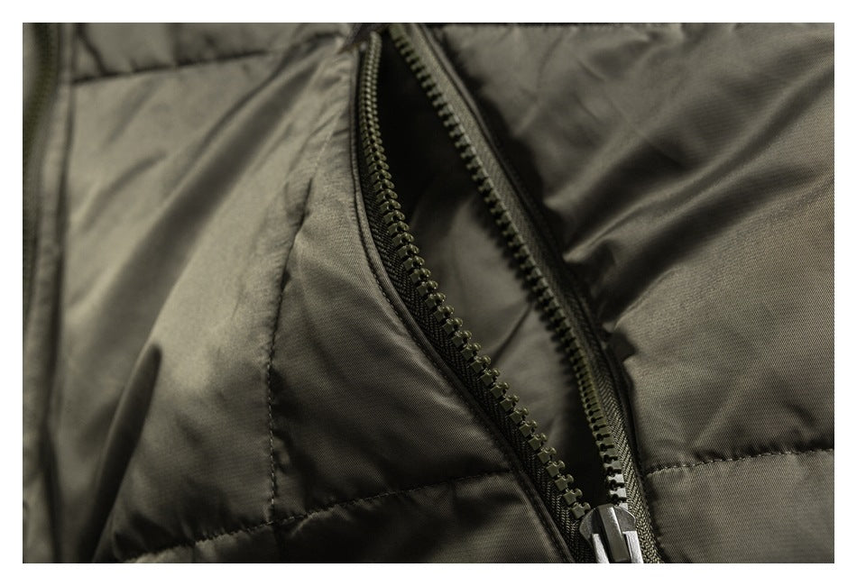 Close-up of an open dark zipper on an olive-gray padded jacket.