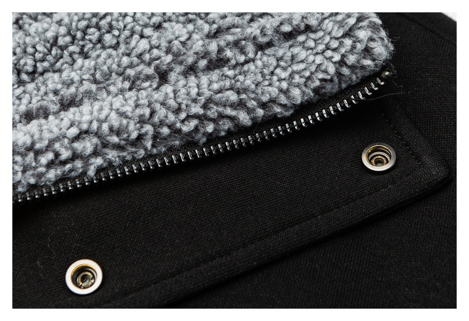 Close-up of a black garment with a silver zipper, snap fasteners, and gray textured lining.