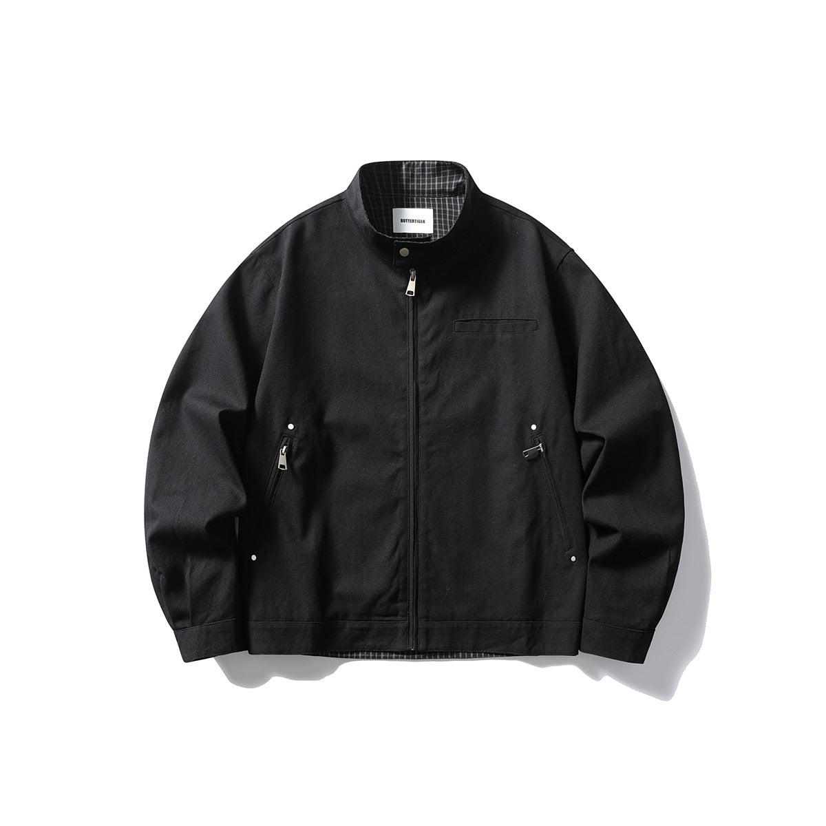 Black stand-collar zip-up jacket flat lay with chest welt pocket, diagonal zip pockets and checked lining at collar