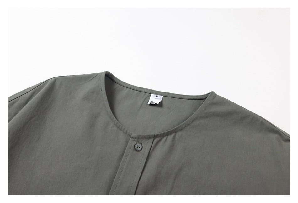 Close-up of the dark gray shirt's round neckline, single-button placket, and neck label.