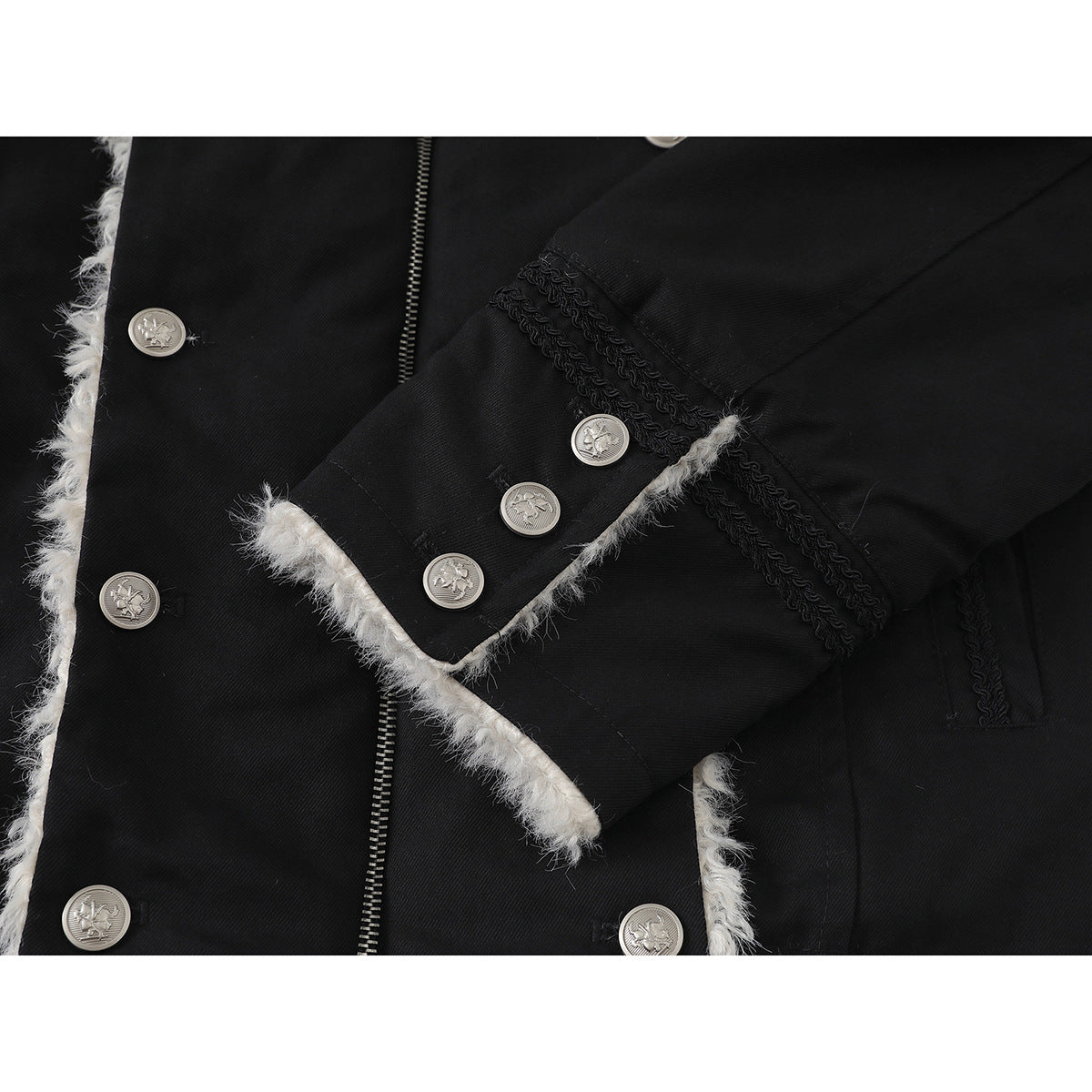 Close-up of a black jacket cuff with silver buttons, braided trim, and white fluffy edging.