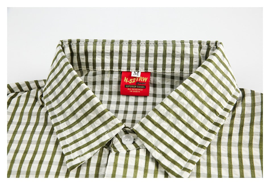 Close-up of an olive-and-white checked shirt collar with a red neck label.