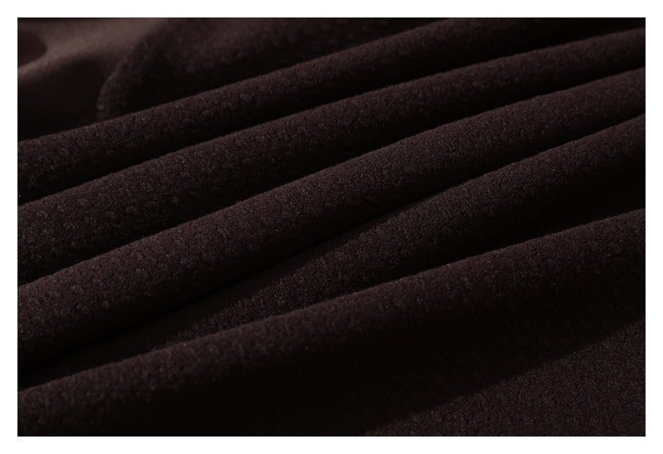 Close-up of dark brown textured fabric arranged in soft parallel folds.