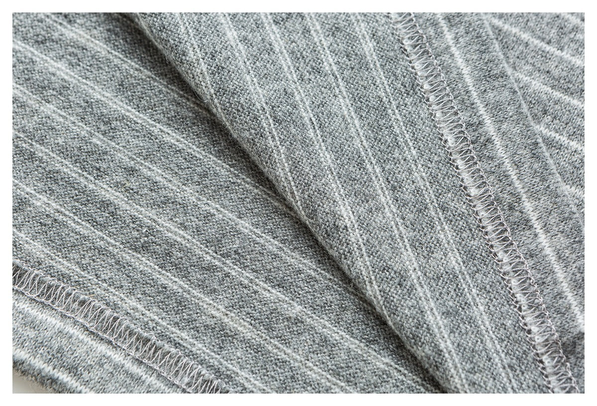 Close-up of the gray-and-white striped knit garment's inside seams and overlock stitching.