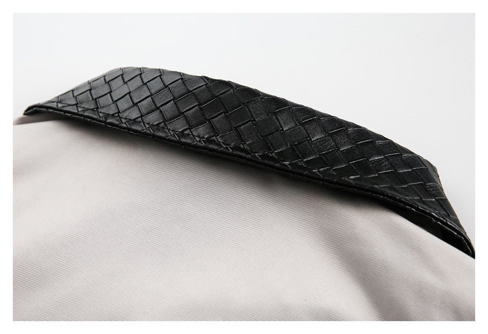 Close-up of black woven trim against light gray apparel.