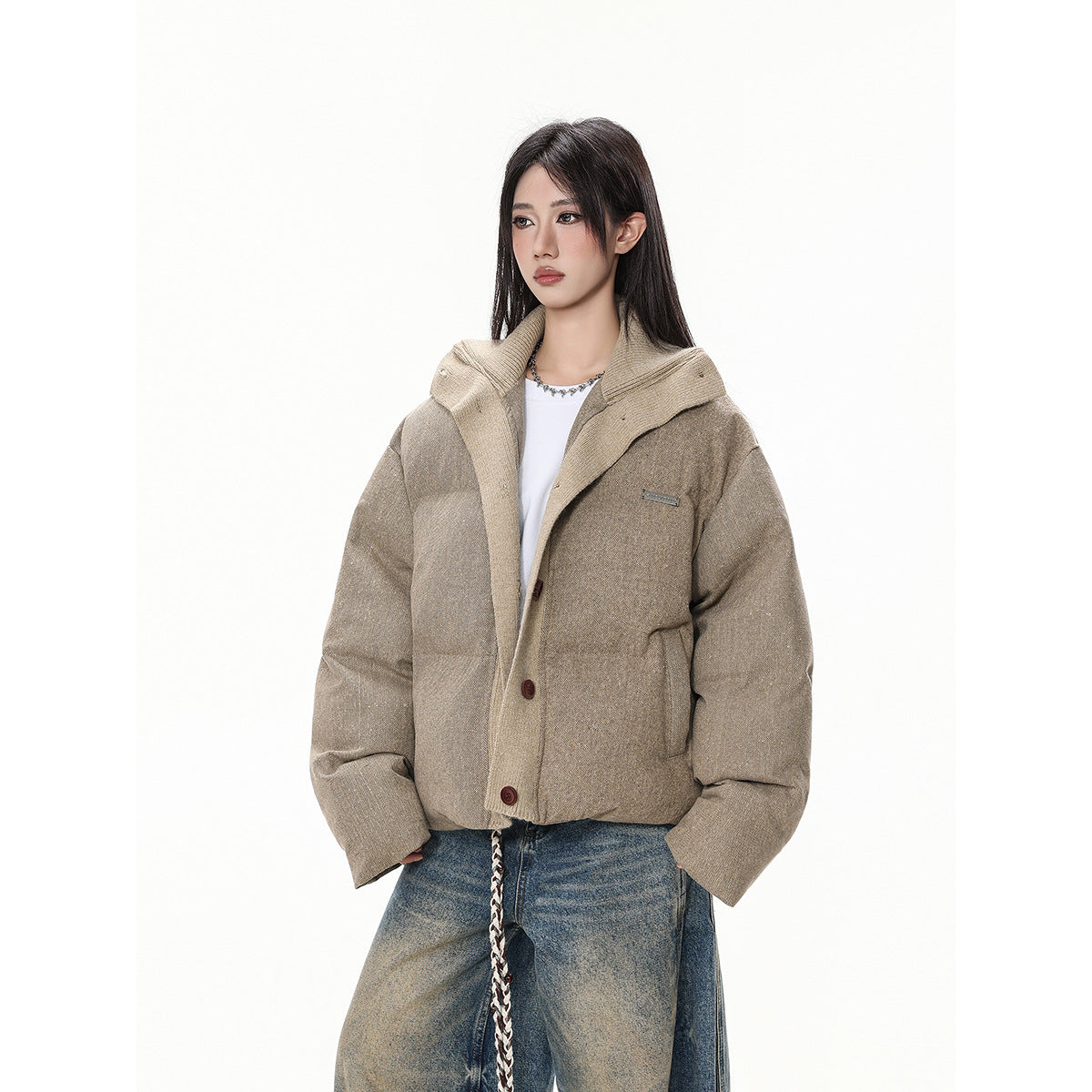Three-quarter view of a model wearing a taupe padded jacket with a wide contrasting collar and button front.