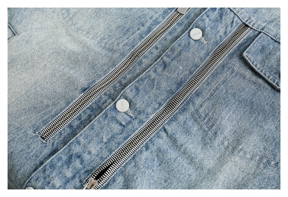 Close-up of a light blue denim jacket showing two parallel metal zippers and silver buttons.