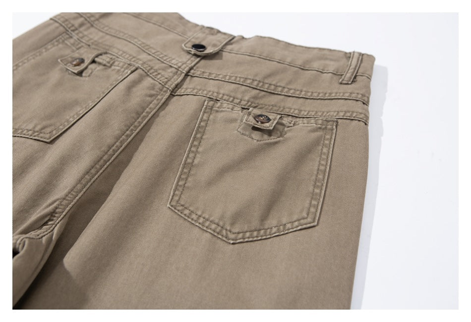 Close-up of the back of taupe pants, showing the waistband and a buttoned rear pocket.