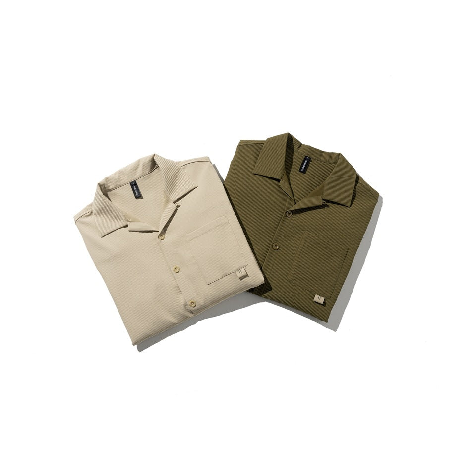 Two folded ribbed short-sleeve collared shirts with buttons and chest pockets, in beige and olive green.