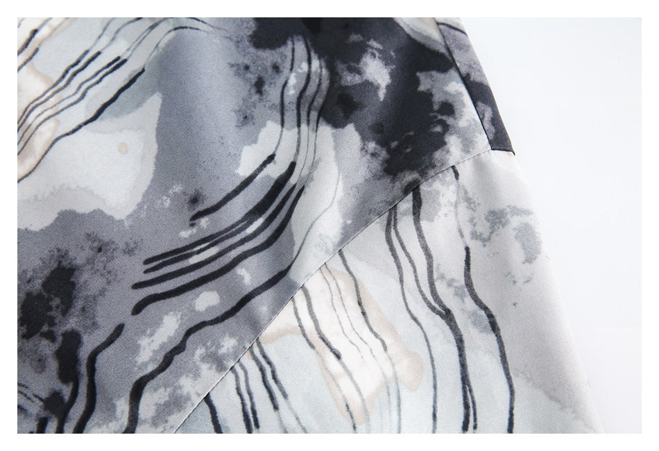 Close-up of the shirt's gray, black, and cream abstract print and a diagonal fabric seam.