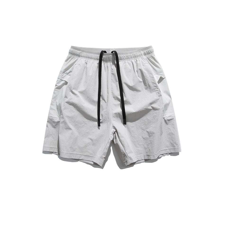 Light gray drawstring shorts with black cords, elastic waistband and side pockets, flat lay front view