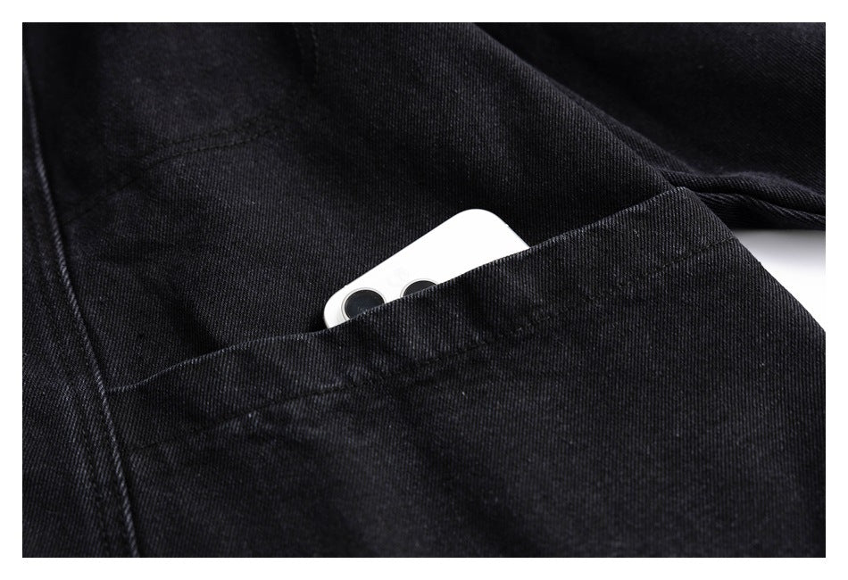Close-up of a black jacket pocket with a white smartphone partly tucked inside.