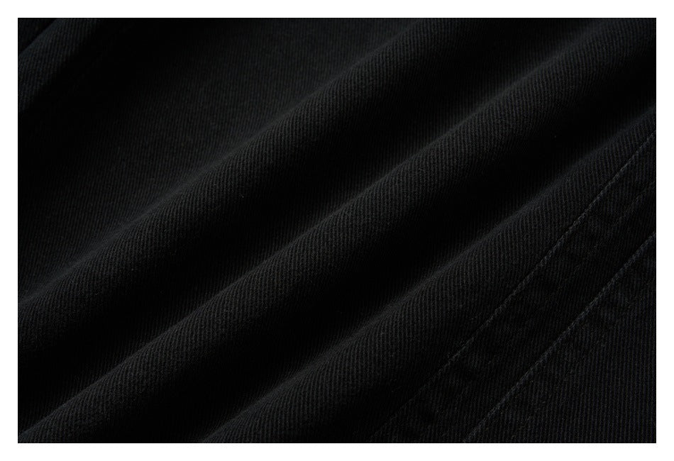 Extreme close-up of the black pants' fabric and diagonal stitching.