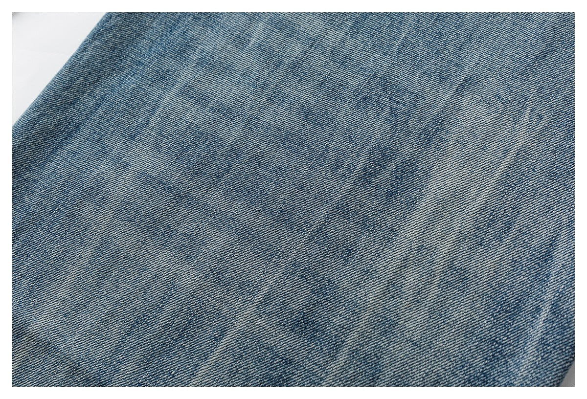 Close-up of blue denim showing an even diagonal twill weave and subtle fading.