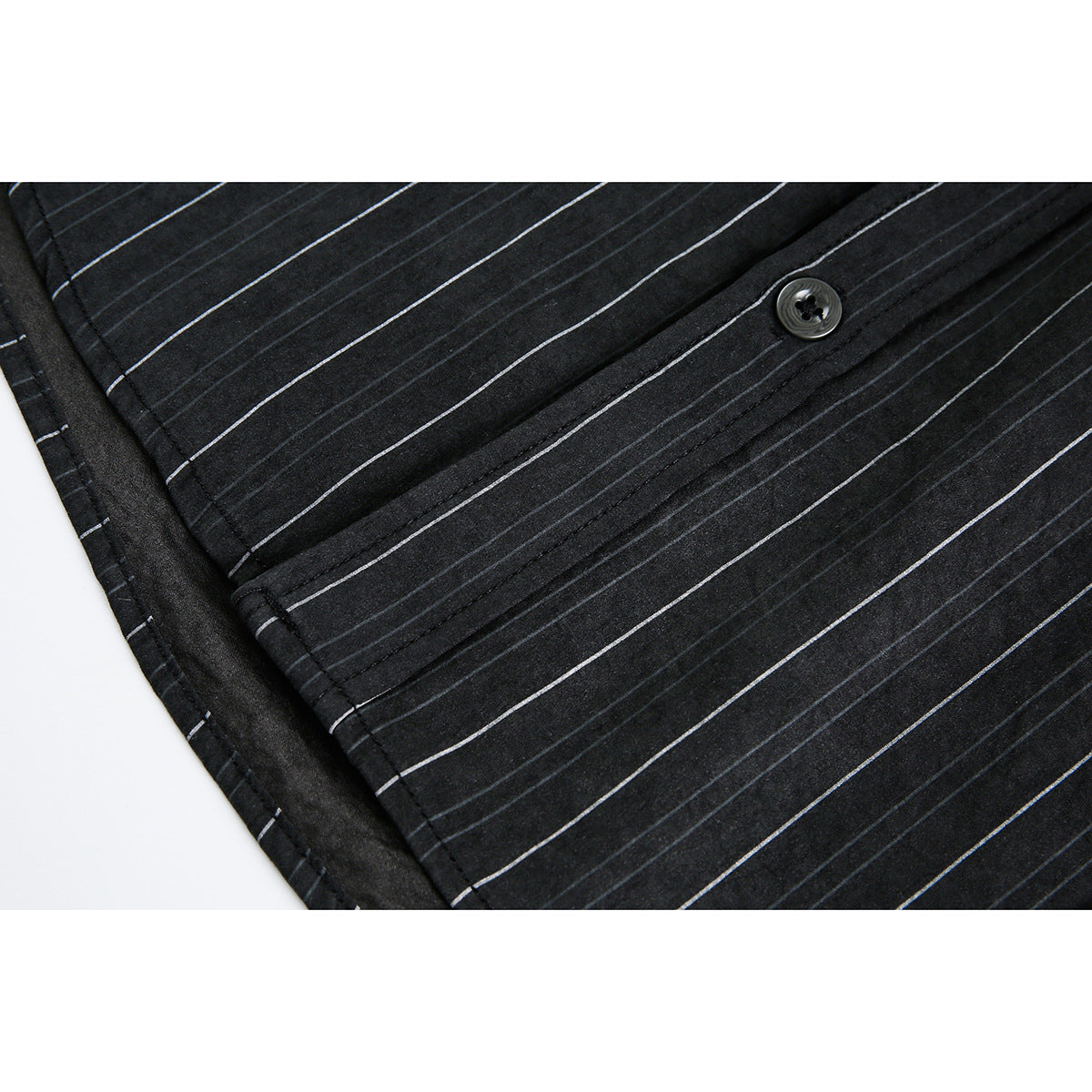 Close-up of a black pinstriped shirt placket and button.