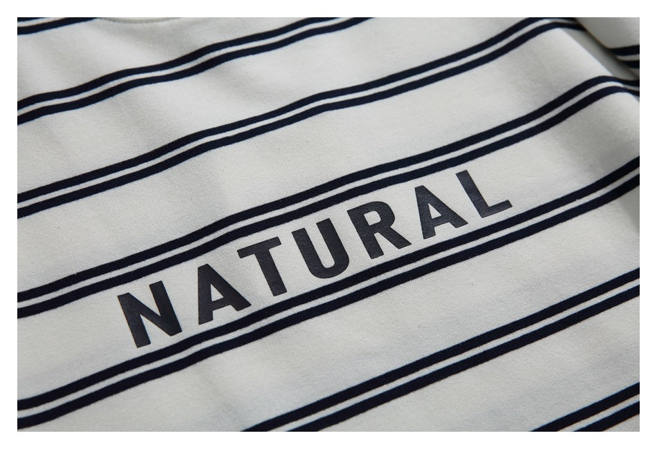 Close-up of the shirt’s navy stripes and bold “NATURAL” chest lettering.