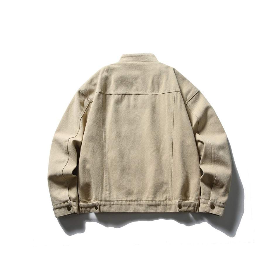 Back view of a sand-colored jacket with a stand collar, panel seams, and adjustable snap tabs at the hem.