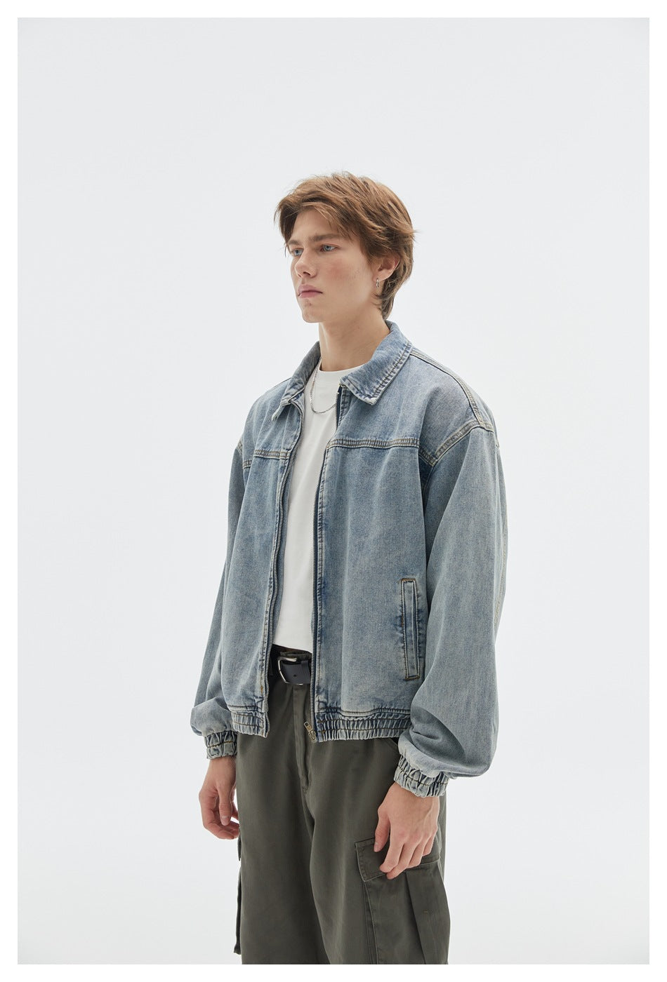 Closer view of a model wearing a light blue zip-front denim jacket with a pointed collar, side pockets, and gathered cuffs.