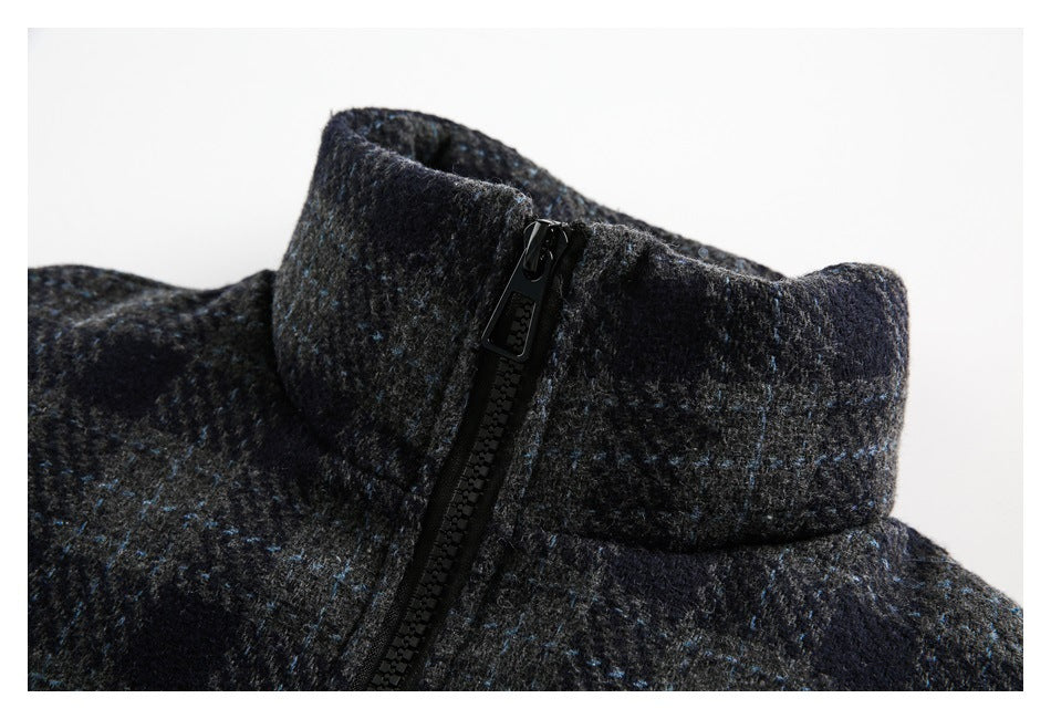 Close-up of the jacket's high stand collar and black zipper against dark plaid fabric.