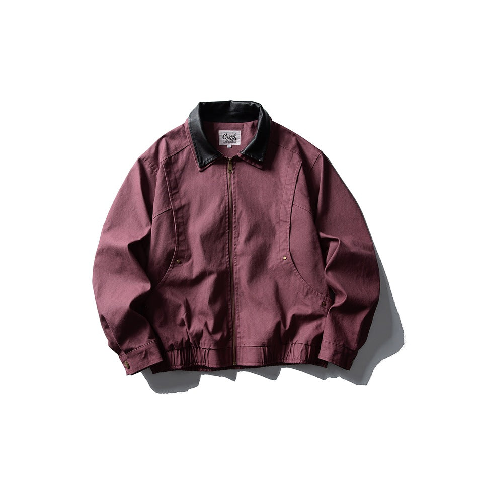 Rubber red zip-front jacket with black collar, curved seams, side rivet pockets and elastic hem, flat lay