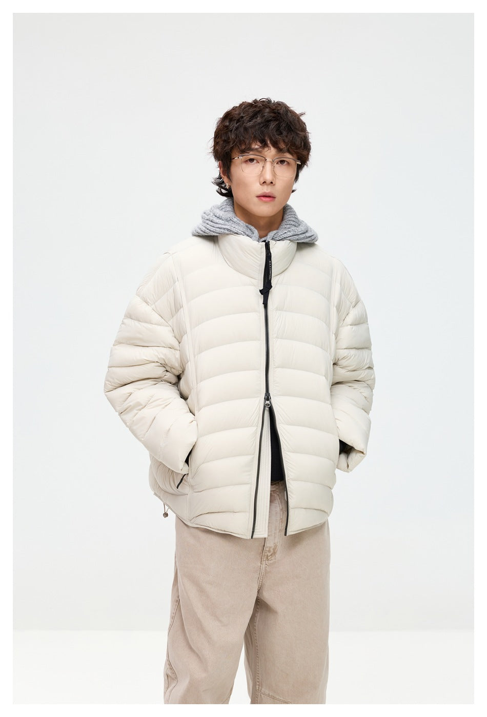 Model wearing an off-white quilted puffer jacket with a high collar and black front zipper, shown from the front.