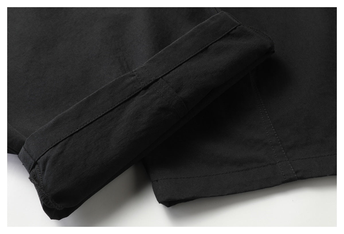 Close-up of a black garment cuff or hem folded back to show its stitching.