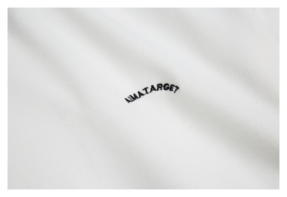 Close-up of small black embroidered lettering on white fabric.