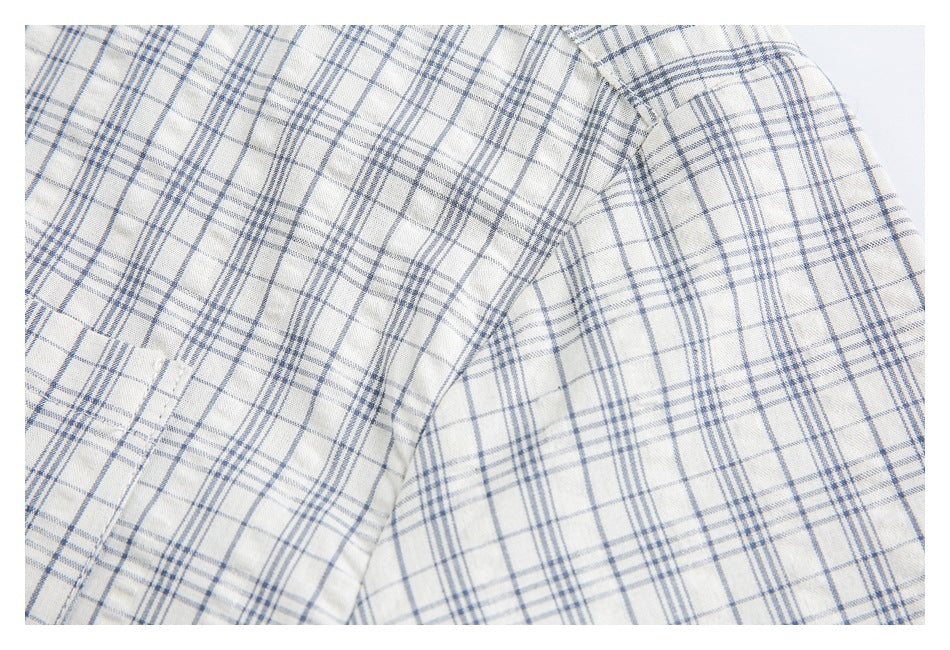 Close-up of blue-gray plaid shirt fabric at the shoulder and sleeve seam.