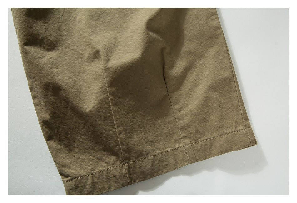 Close-up of the straight stitched hem on a khaki trouser leg.