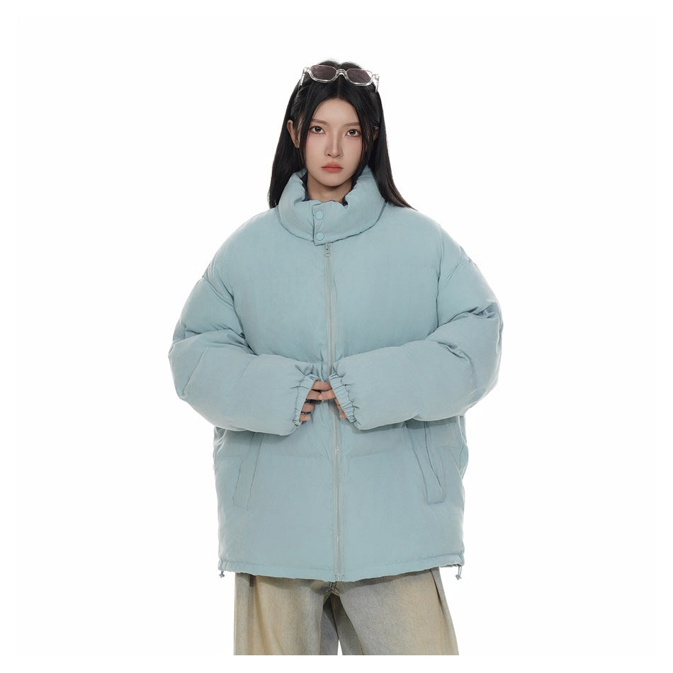 Model wearing a zipped pale blue padded jacket with a tall buttoned collar and front pockets, front view.