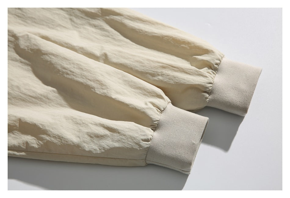 Close-up of an ivory garment's gathered sleeves and wide ribbed cuffs.