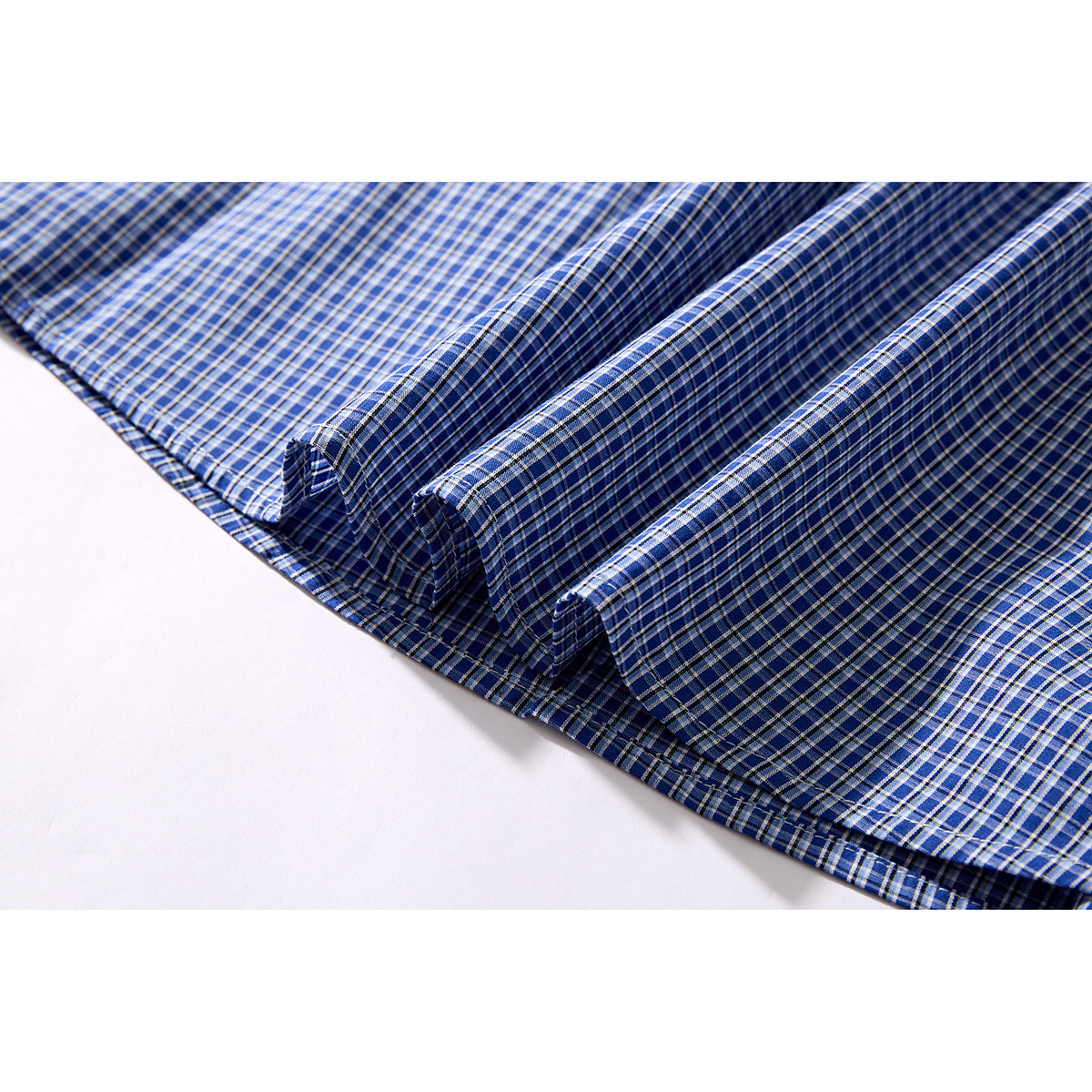 Blue plaid shirt fabric arranged in folds, showing the checked pattern.