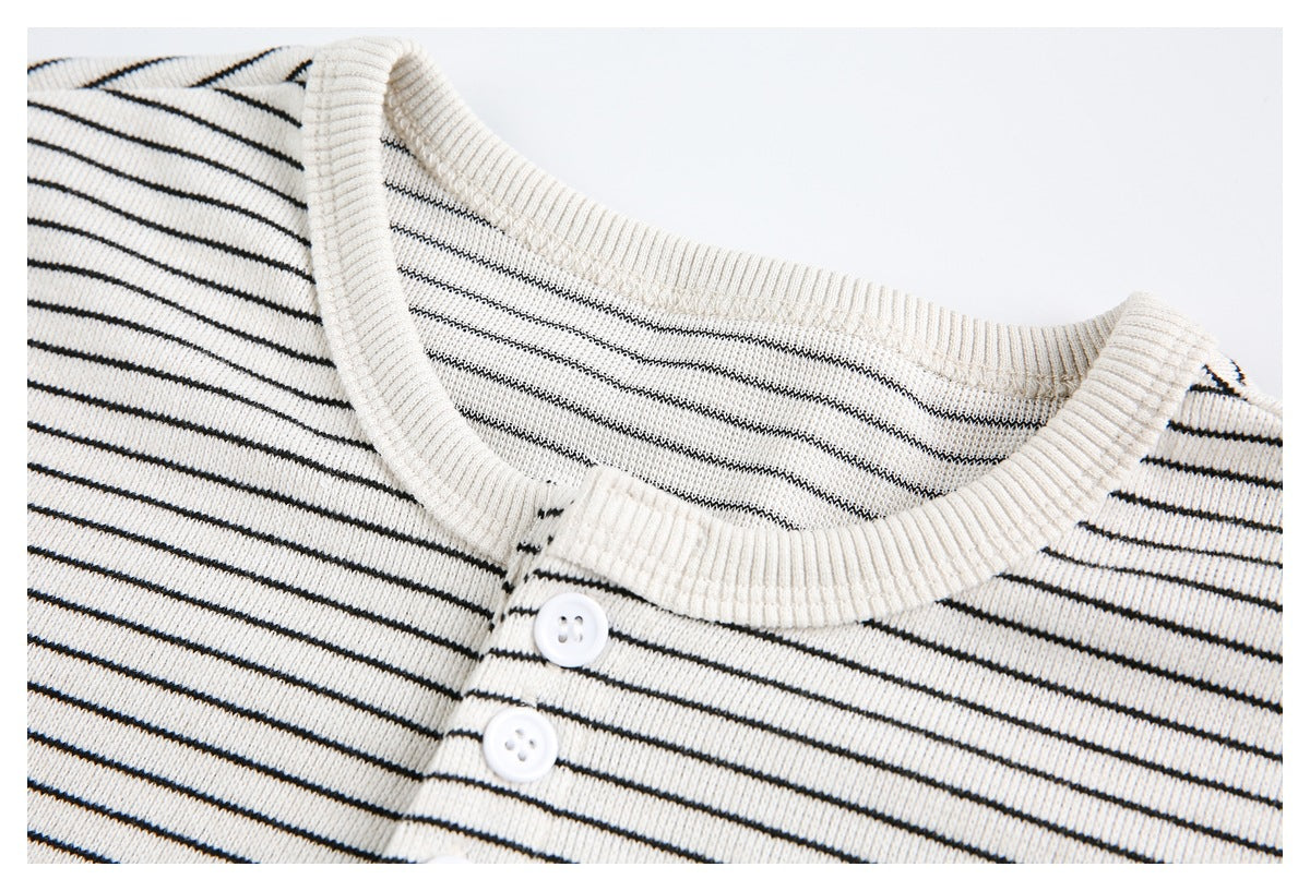 Close-up of the ivory striped T-shirt's ribbed crew neckline and two-button placket.