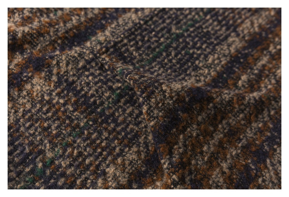 Close-up of a fold in mottled brown, navy, beige, and green patterned fabric.