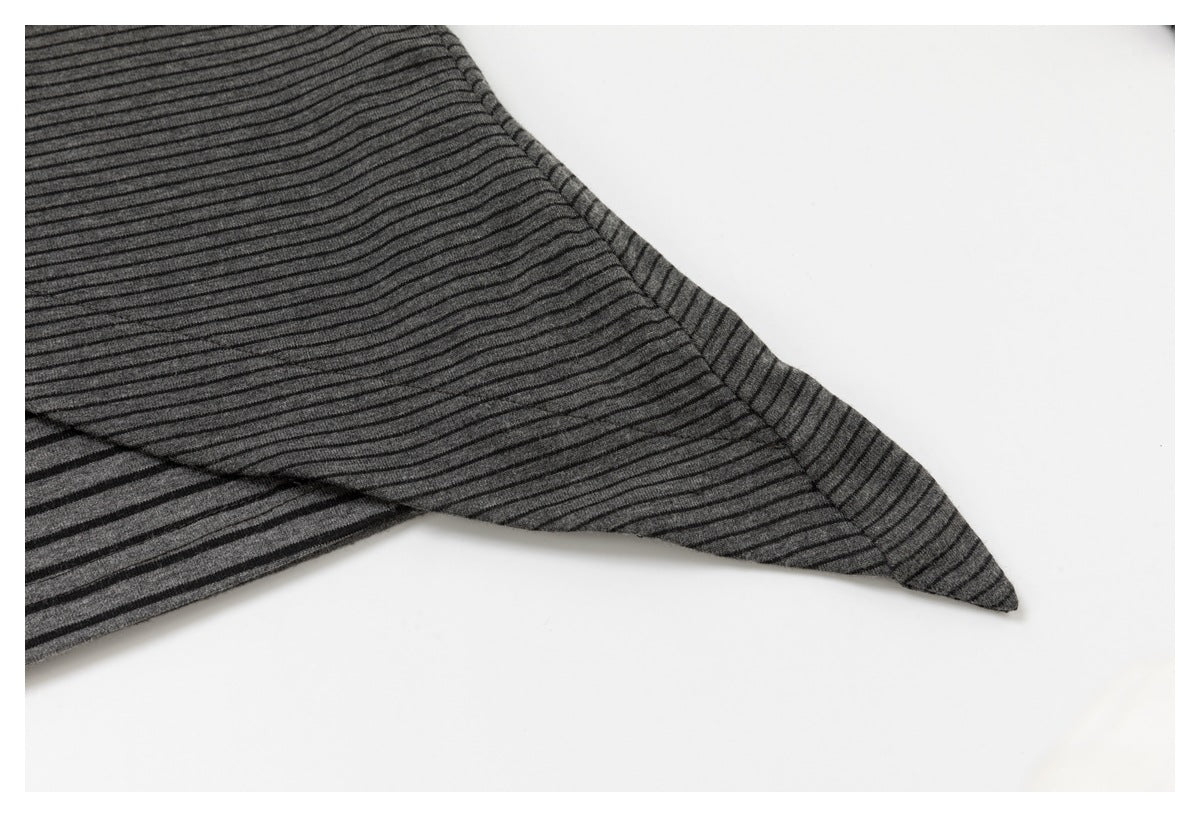 Close-up of the pointed edge and seam of a charcoal top with fine black stripes.