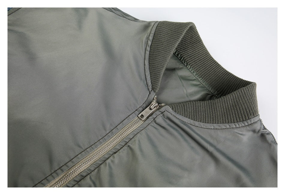 Close-up of a gray bomber jacket's ribbed collar and diagonal metal zipper.