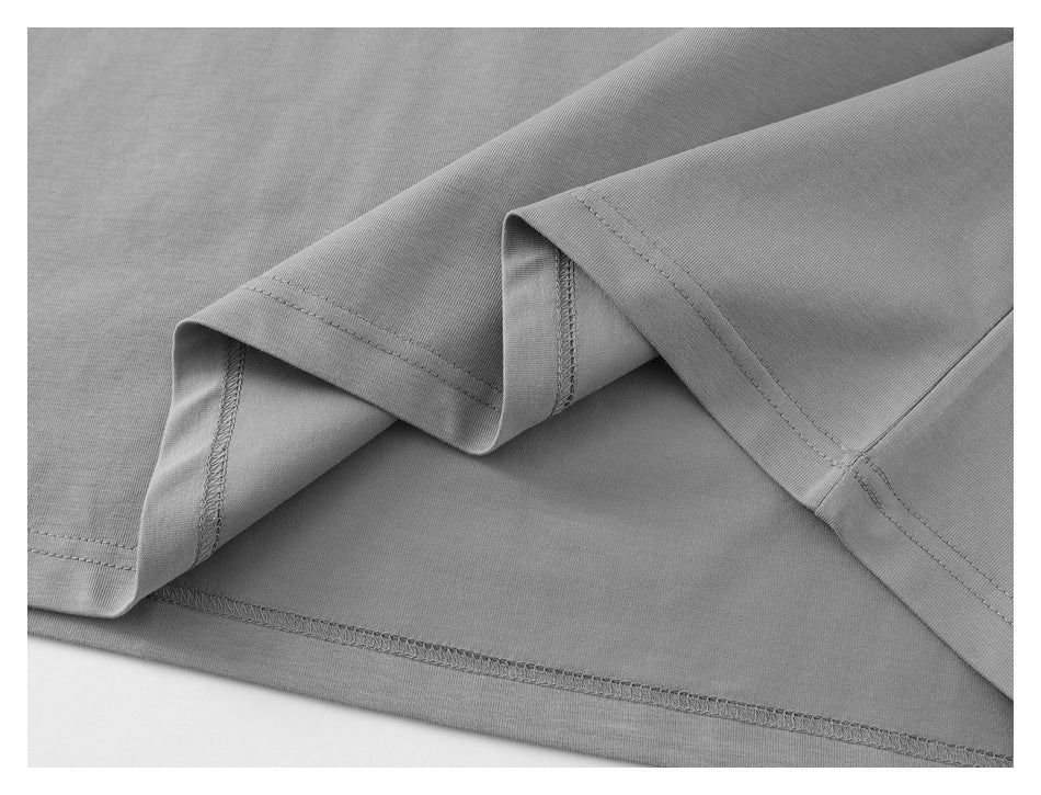 Close-up of the gray polo shirt’s folded hem and visible overlock stitching.