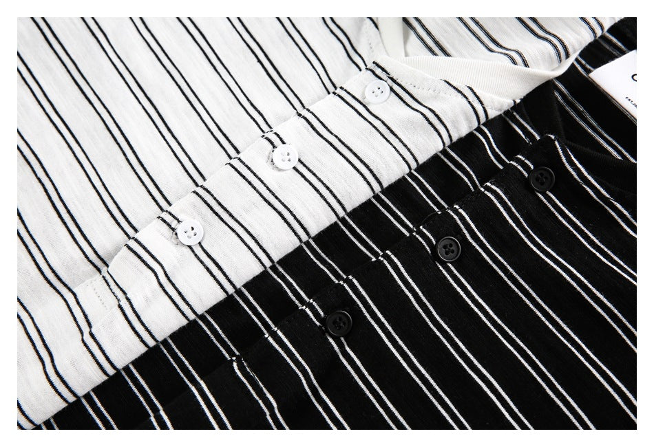 Close-up of white and black tops with thin vertical white stripes and button plackets.