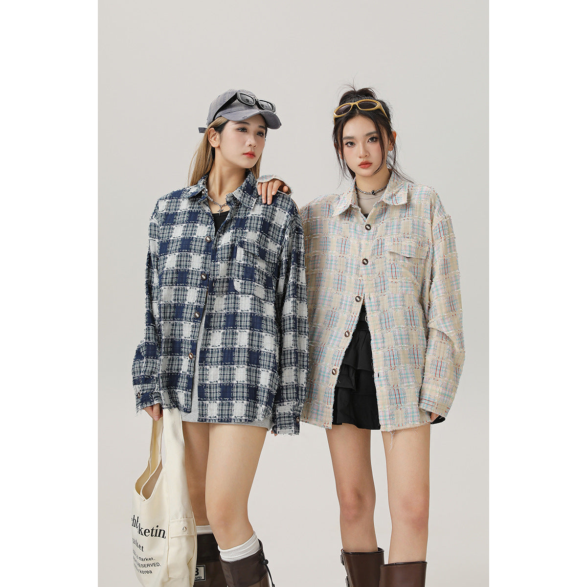 Two models wear oversized button-front plaid shirts in navy and cream, styled with shorts and boots.